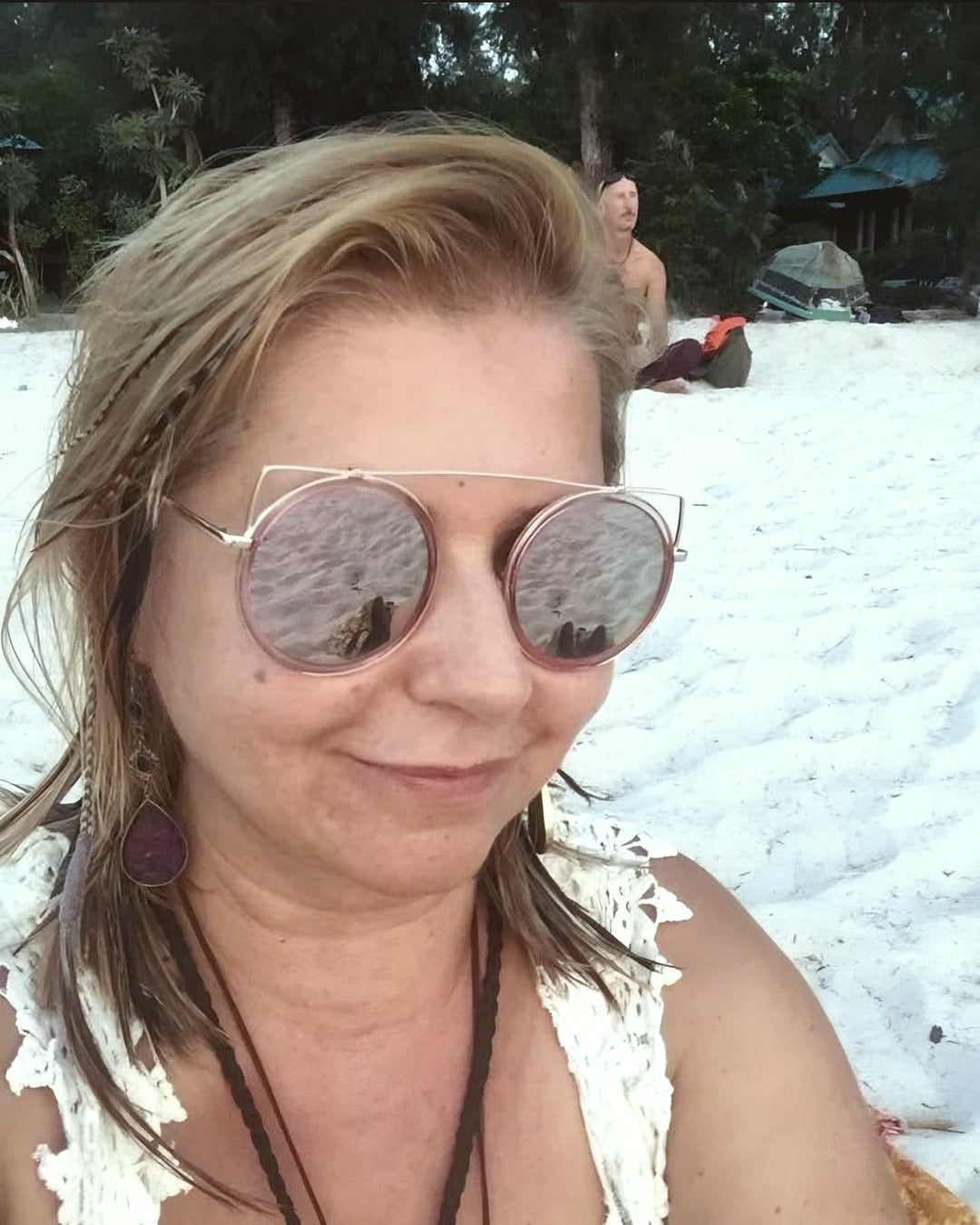 Elena Goncharova, founder of Best Plan No Plan, smiling on the beach in sunglasses