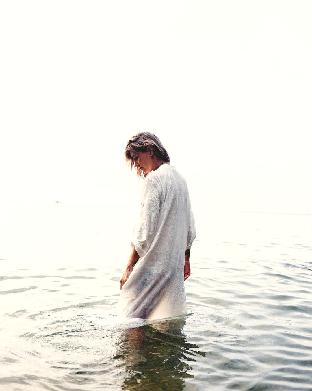 Standing in the sea off Koh Phangan in a natural-fibre dress