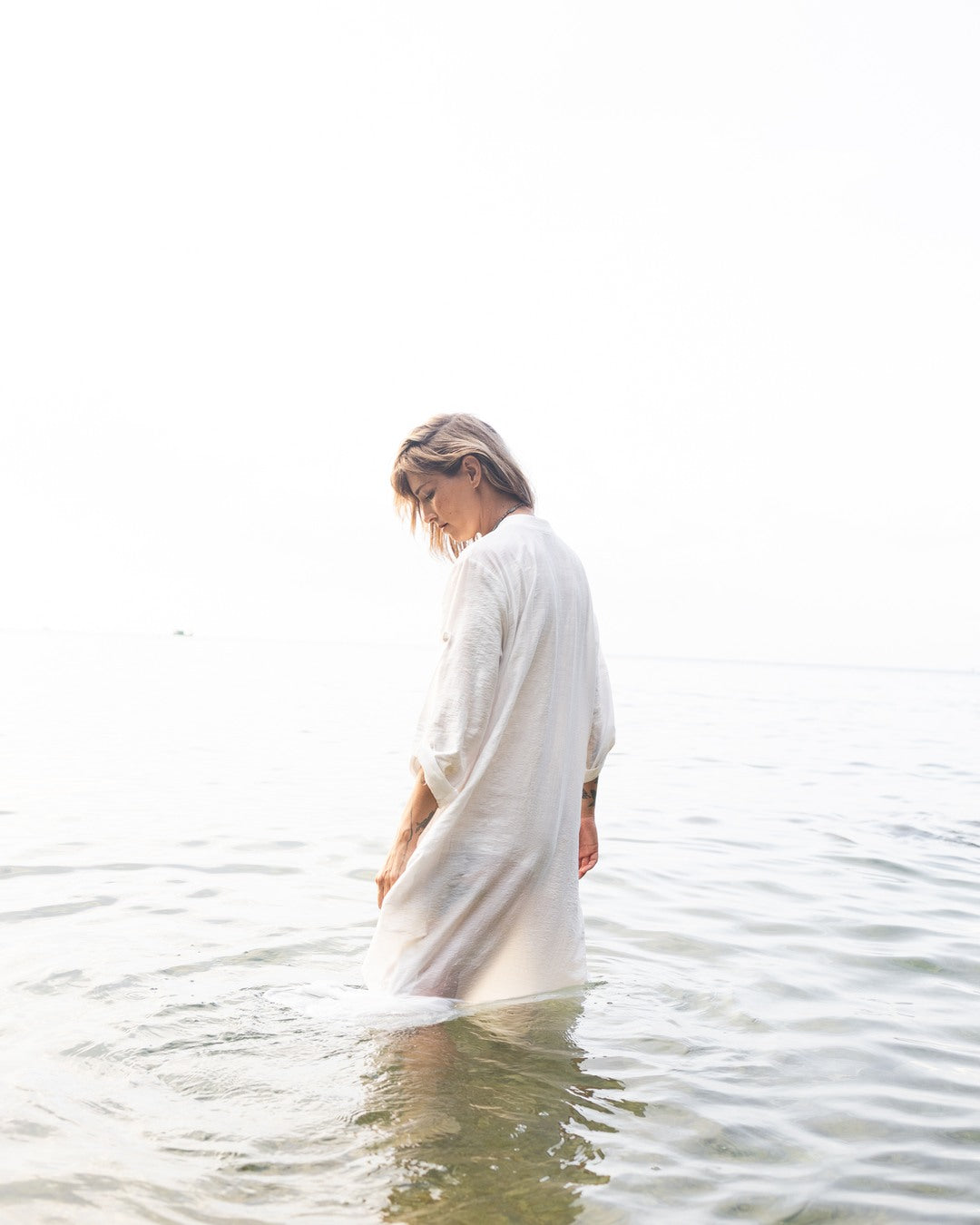 Standing in the sea off Koh Phangan in a natural-fibre dress